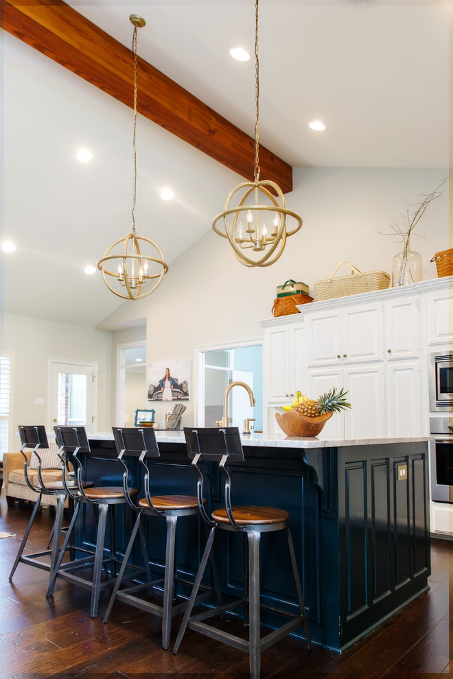 Large transitional dark wood floor and brown floor eat-in kitchen photo in New Orleans with an undermount sink, raised-panel cabinets, white cabinets, marble countertops, white backsplash, stainless steel appliances and an island