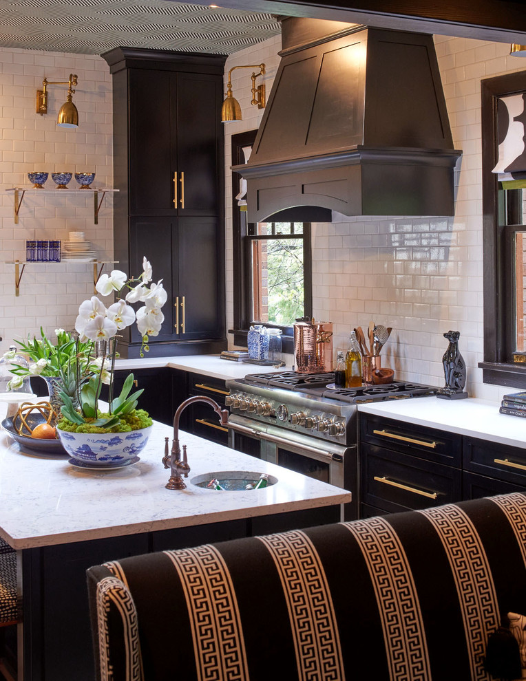 Classic l-shaped kitchen/diner in Raleigh with recessed-panel cabinets, black cabinets, engineered stone countertops, white splashback, ceramic splashback, stainless steel appliances and an island.