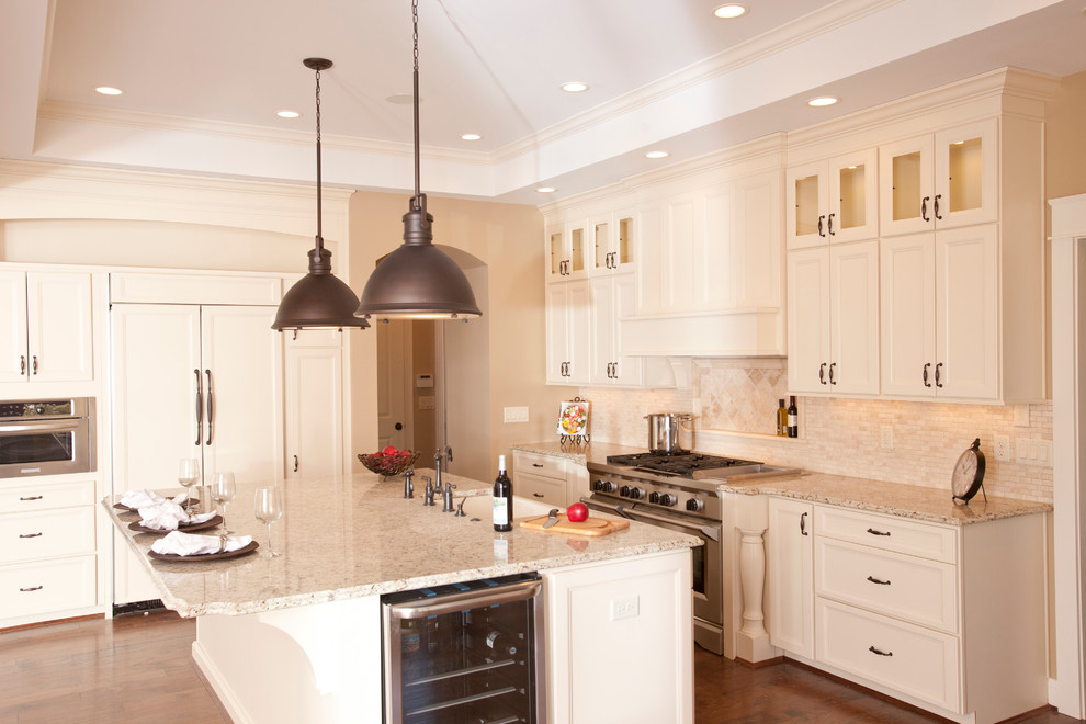 Example of a classic l-shaped eat-in kitchen design in Cincinnati with an undermount sink, recessed-panel cabinets, white cabinets, granite countertops, beige backsplash, stone tile backsplash and paneled appliances