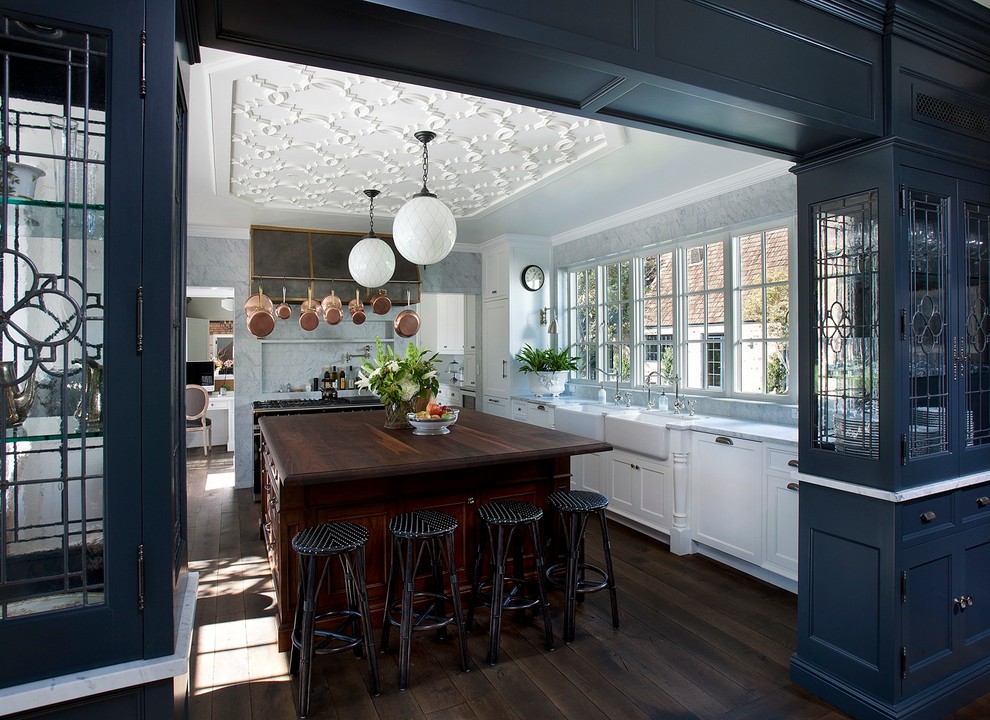 Design ideas for a traditional kitchen in Phoenix with glass-front cabinets and wood worktops.
