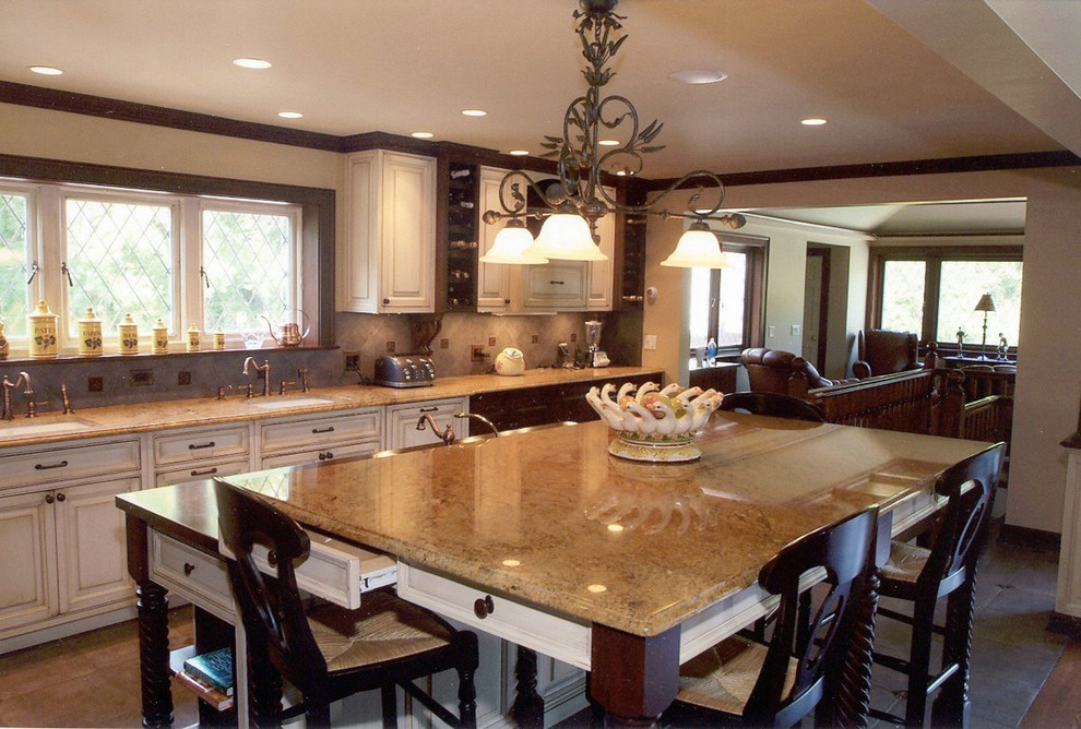 Inredning av ett klassiskt stort kök, med en undermonterad diskho, luckor med upphöjd panel, vita skåp, granitbänkskiva, beige stänkskydd, stänkskydd i keramik, rostfria vitvaror, klinkergolv i keramik, en köksö och brunt golv