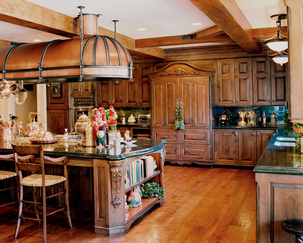 Diseño de cocina comedor clásica con armarios con paneles empotrados, puertas de armario de madera oscura, encimera de granito y una isla