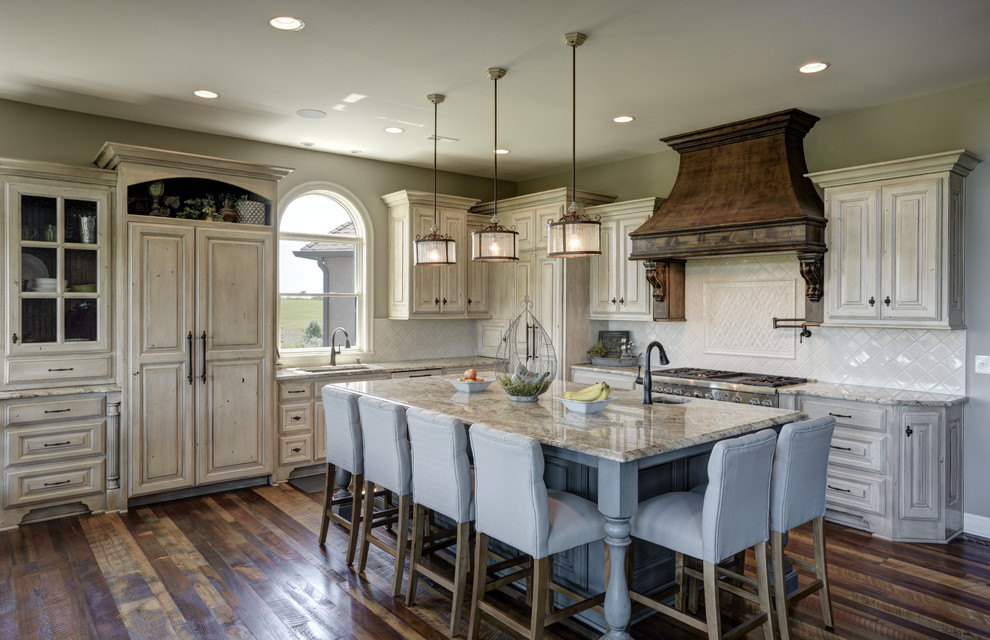 Traditional l-shaped kitchen in Other with a submerged sink, raised-panel cabinets, white cabinets, white splashback, integrated appliances, dark hardwood flooring, an island, brown floors and beige worktops.