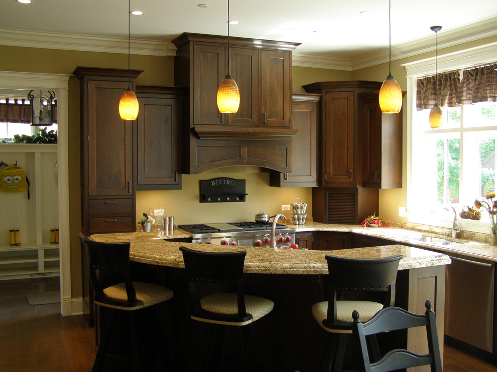 Foto di una cucina chic con ante con riquadro incassato, ante in legno bruno e elettrodomestici in acciaio inossidabile
