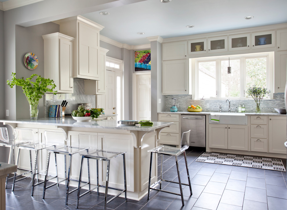 Klassisk inredning av ett kök, med rostfria vitvaror, en rustik diskho och grått golv