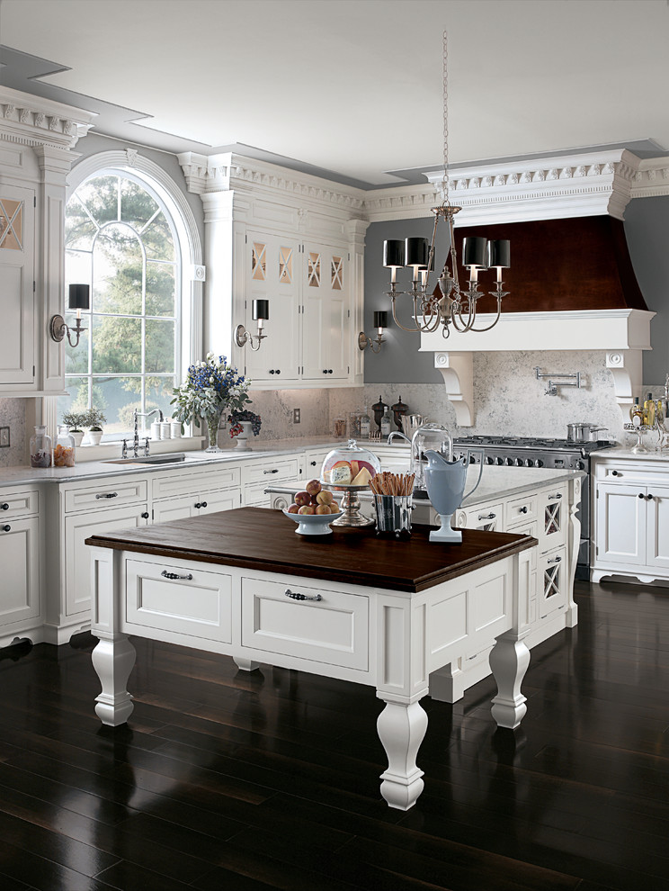 Design ideas for an expansive traditional u-shaped kitchen/diner in Tampa with wood worktops, white splashback, stainless steel appliances, a built-in sink, white cabinets, dark hardwood flooring and an island.