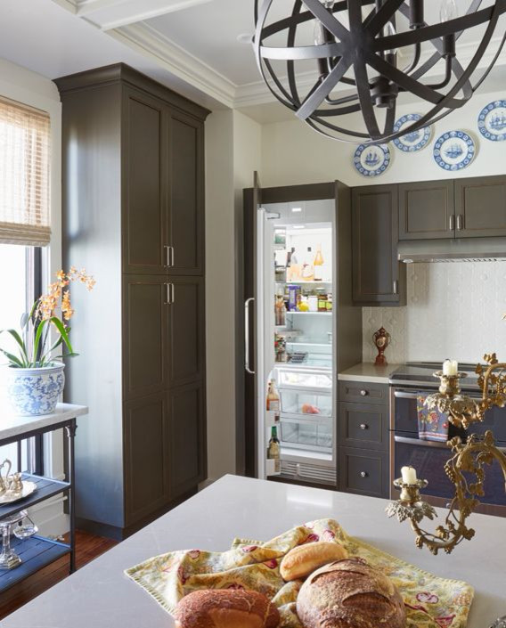 Foto på ett mellanstort vintage beige kök, med en undermonterad diskho, luckor med infälld panel, bruna skåp, bänkskiva i kvarts, vitt stänkskydd, stänkskydd i keramik, rostfria vitvaror, mellanmörkt trägolv, en halv köksö och brunt golv