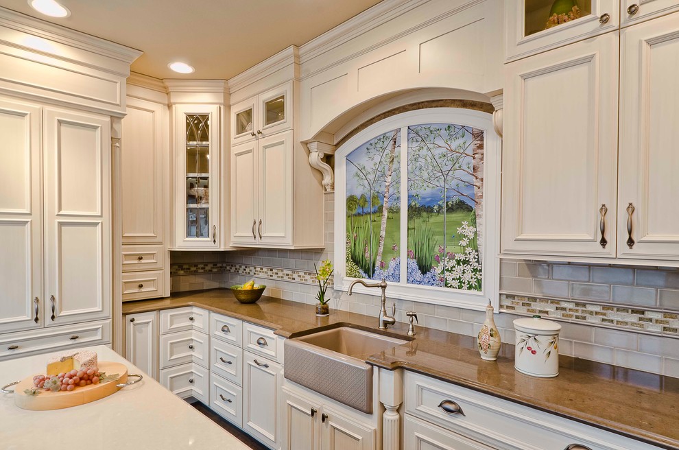 Elegant kitchen photo in Chicago with a farmhouse sink, recessed-panel cabinets, beige cabinets, beige backsplash and subway tile backsplash