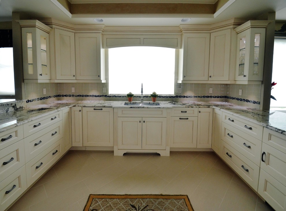 Inspiration for an u-shaped eat-in kitchen remodel in Miami with an undermount sink, white cabinets, granite countertops, multicolored backsplash, mosaic tile backsplash and stainless steel appliances