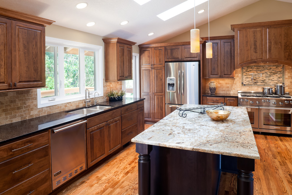 This is an example of a traditional kitchen in Portland with stainless steel appliances, a submerged sink and granite worktops.