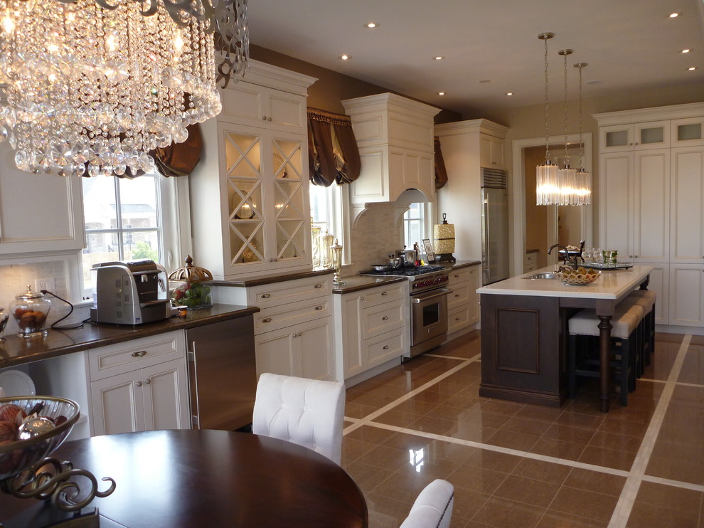 Imagen de cocina comedor clásica con armarios con paneles empotrados, puertas de armario blancas y electrodomésticos de acero inoxidable