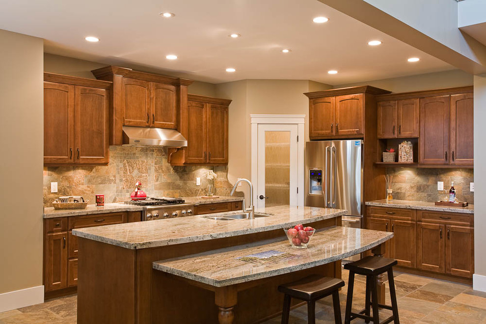 Inspiration for a timeless kitchen remodel in Vancouver with stainless steel appliances, granite countertops, a double-bowl sink, recessed-panel cabinets, medium tone wood cabinets, multicolored backsplash and stone tile backsplash