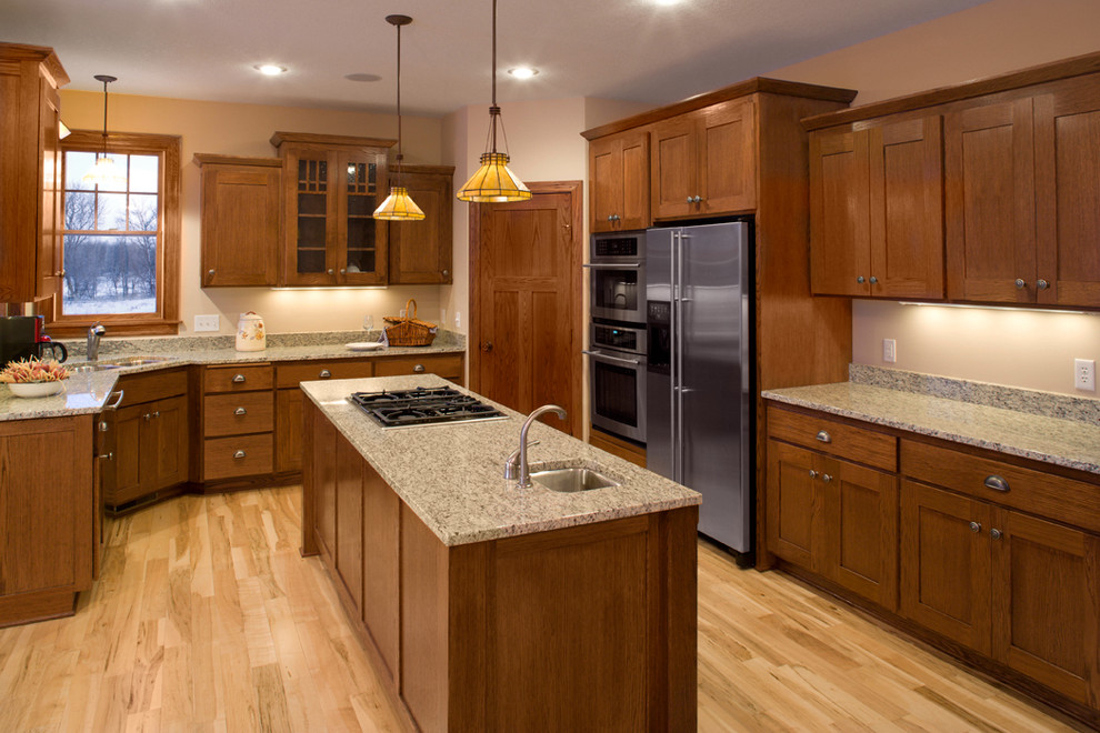 Traditional kitchen in Minneapolis with shaker cabinets, medium wood cabinets and stainless steel appliances.
