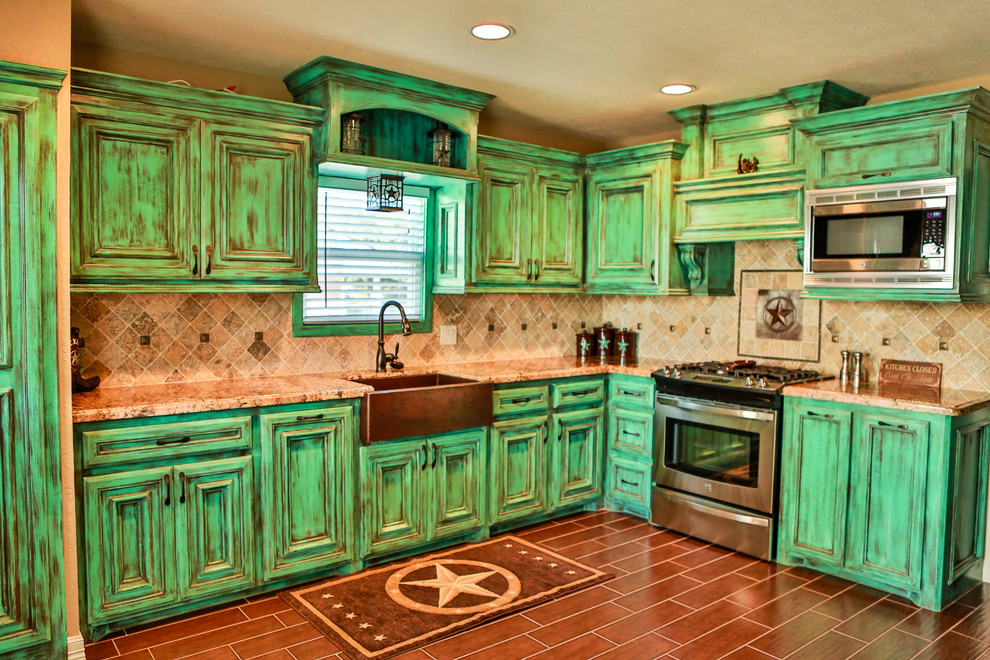 ヒューストンにあるトラディショナルスタイルのおしゃれなキッチン (シルバーの調理設備、ヴィンテージ仕上げキャビネット、エプロンフロントシンク、ベージュキッチンパネル) の写真