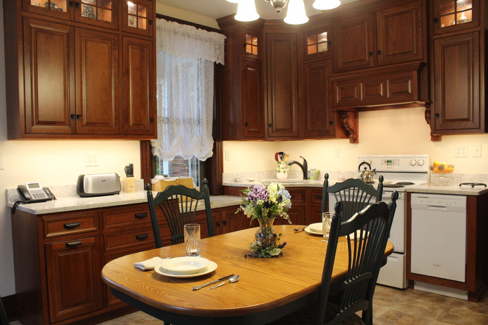 Klassisk inredning av ett mellanstort kök, med en undermonterad diskho, luckor med upphöjd panel, skåp i mellenmörkt trä, bänkskiva i kvarts, beige stänkskydd, vita vitvaror, laminatgolv och beiget golv
