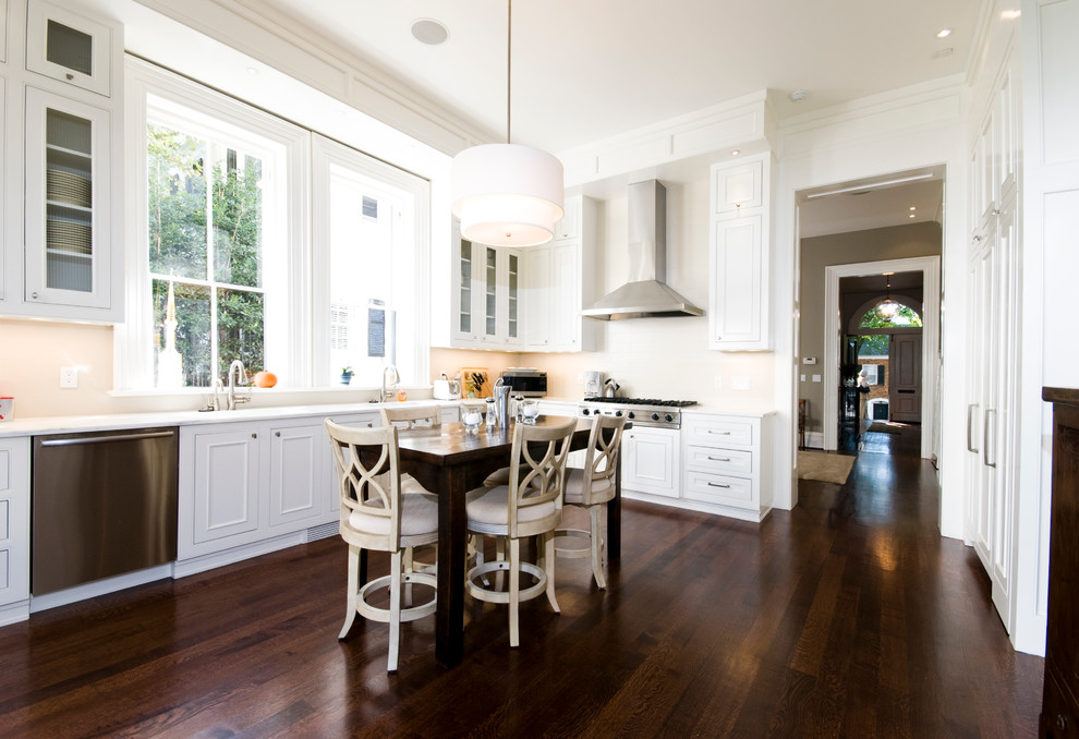 Example of a classic brown floor kitchen design in DC Metro with white cabinets, stainless steel appliances, white countertops and beaded inset cabinets