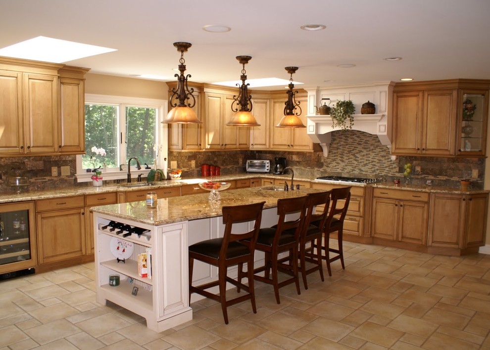 Exempel på ett stort klassiskt beige beige l-kök, med en undermonterad diskho, luckor med upphöjd panel, skåp i mellenmörkt trä, granitbänkskiva, grått stänkskydd, stänkskydd i stenkakel, travertin golv, en köksö och beiget golv