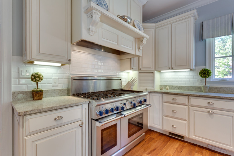 Klassische Wohnküche mit profilierten Schrankfronten, weißen Schränken und Küchengeräten aus Edelstahl in Washington, D.C.