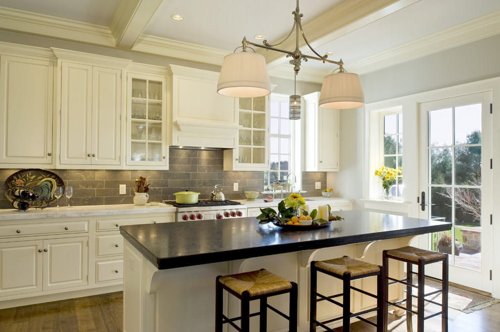 Example of a classic kitchen design in Philadelphia with stainless steel appliances, gray backsplash, white cabinets, raised-panel cabinets and limestone backsplash