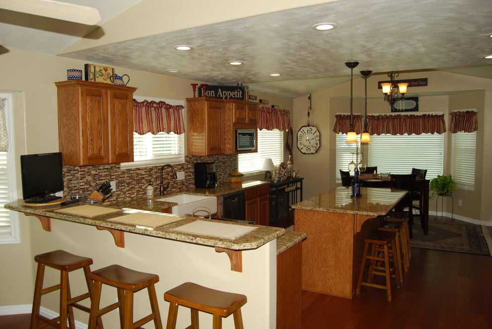 Bild på ett mellanstort vintage kök, med en rustik diskho, luckor med upphöjd panel, skåp i mellenmörkt trä, granitbänkskiva, flerfärgad stänkskydd, stänkskydd i stickkakel, rostfria vitvaror, mörkt trägolv, en köksö och brunt golv