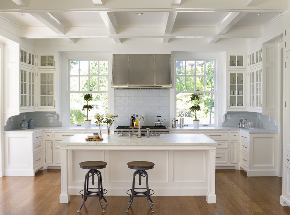 Example of a small classic u-shaped dark wood floor open concept kitchen design in Seattle with a farmhouse sink, glass-front cabinets, white cabinets, marble countertops, gray backsplash, ceramic backsplash, stainless steel appliances and an island