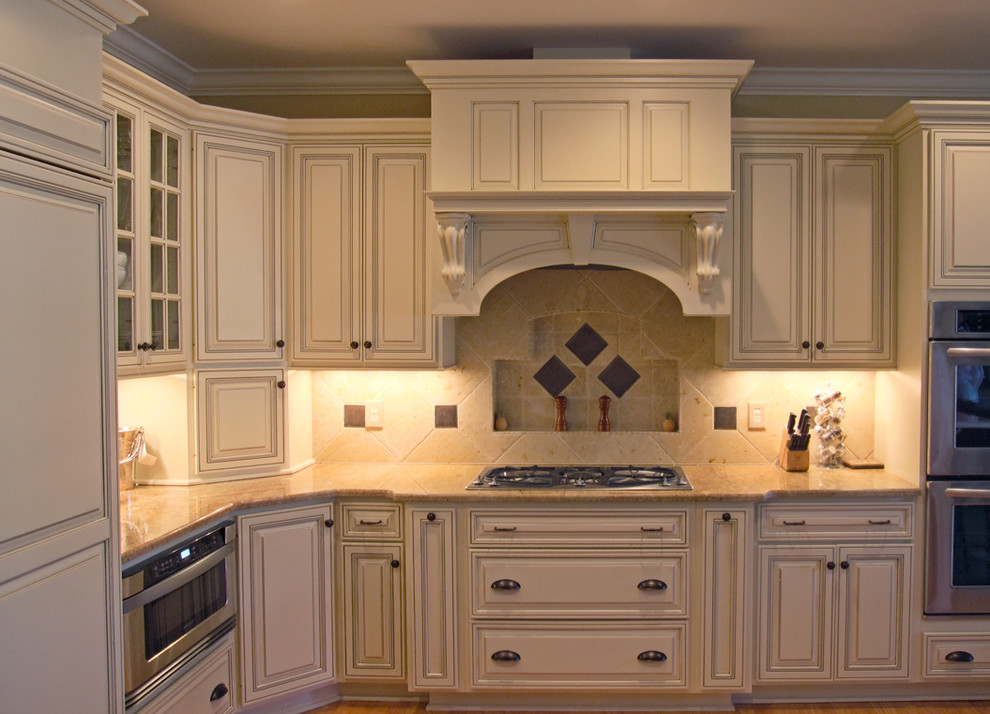 Elegant l-shaped eat-in kitchen photo in Raleigh with an undermount sink, raised-panel cabinets, white cabinets, granite countertops, multicolored backsplash, stone tile backsplash and stainless steel appliances