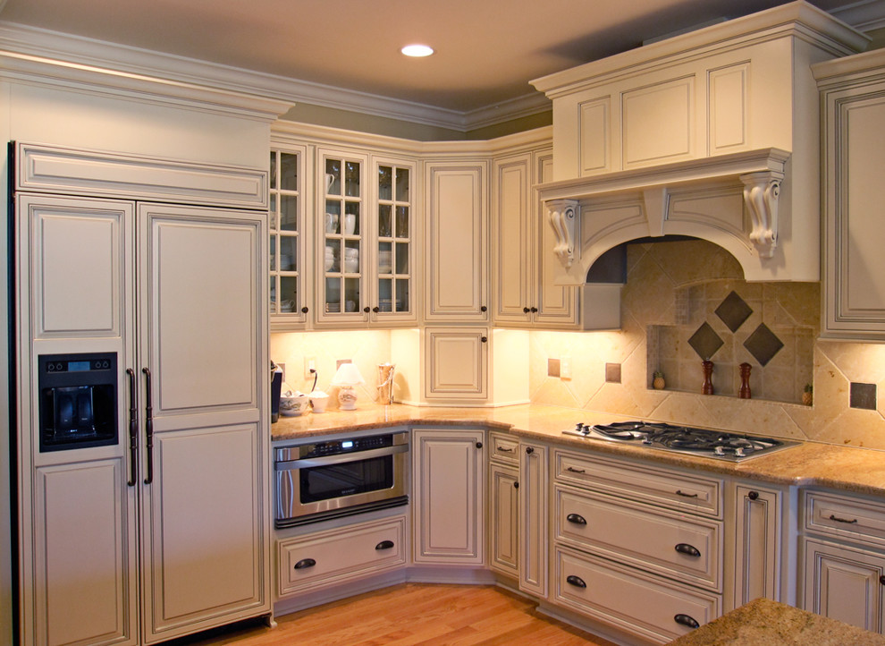 Inspiration for a timeless l-shaped eat-in kitchen remodel in Raleigh with an undermount sink, raised-panel cabinets, white cabinets, granite countertops, multicolored backsplash, stone tile backsplash and stainless steel appliances