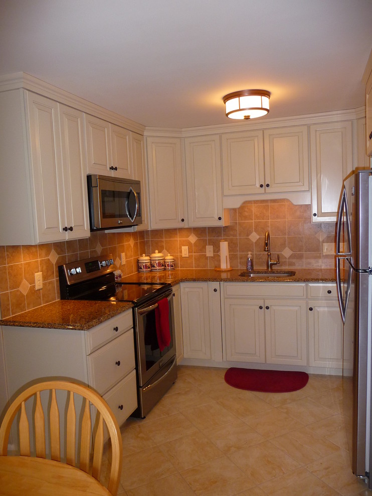 Example of a mid-sized classic ceramic tile kitchen design in Other with a single-bowl sink, raised-panel cabinets, white cabinets, laminate countertops, beige backsplash, glass tile backsplash and white appliances