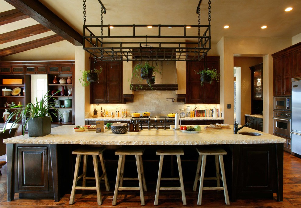 Diseño de cocina comedor tradicional con puertas de armario de madera en tonos medios, salpicadero beige y electrodomésticos de acero inoxidable