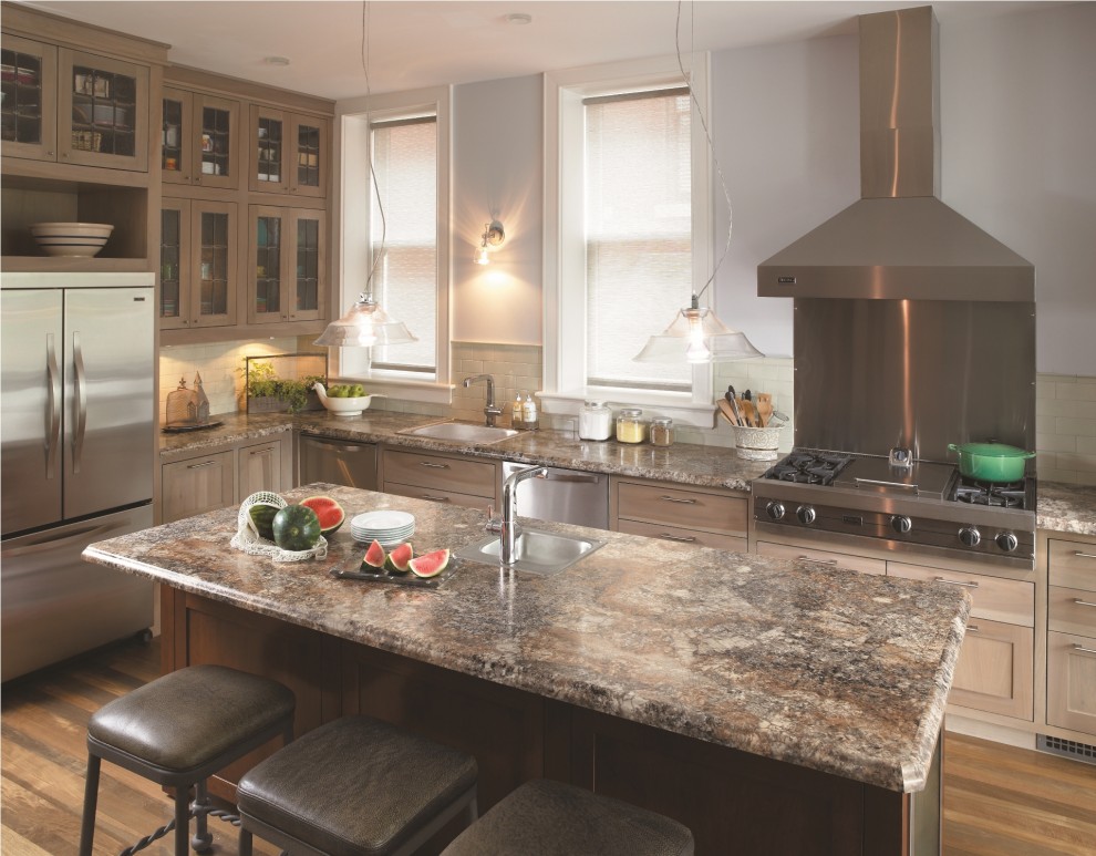 Elegant l-shaped kitchen photo in Cincinnati with glass-front cabinets, stainless steel appliances, a drop-in sink and light wood cabinets