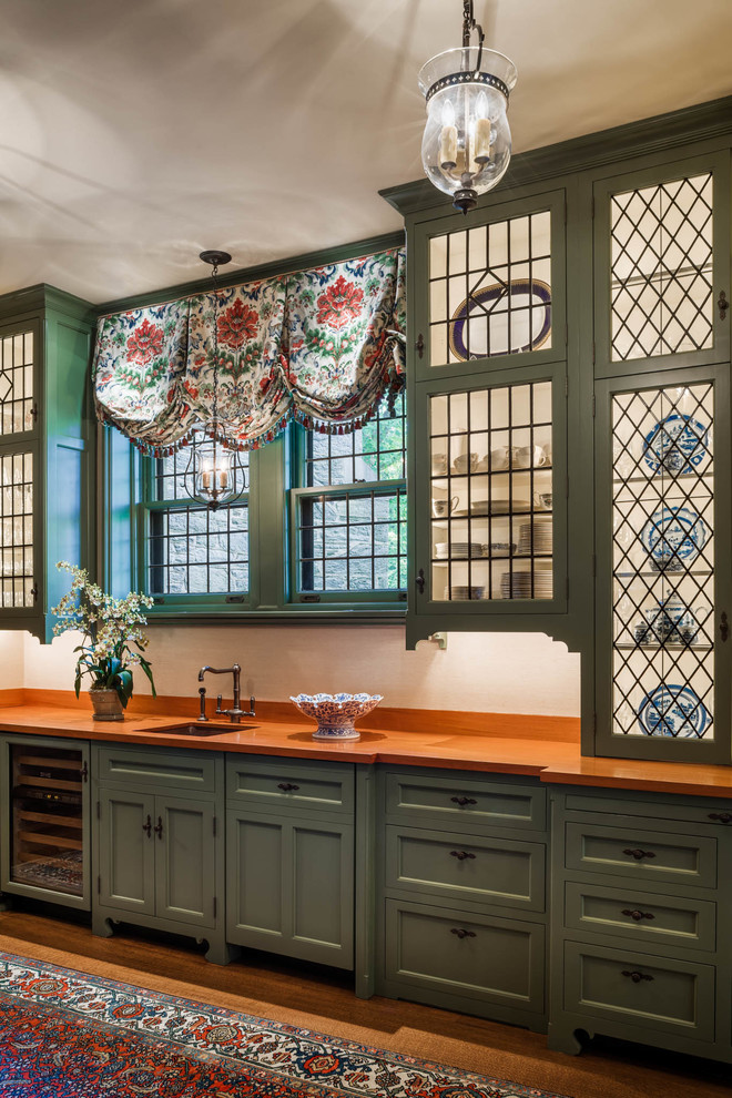 Стильный дизайн: кухня в классическом стиле с стеклянными фасадами и зелеными фасадами - последний тренд