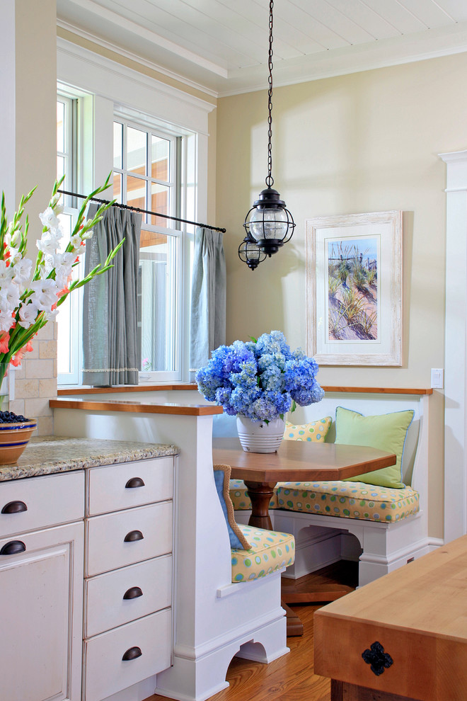 Elegant eat-in kitchen photo in Grand Rapids with white cabinets and beige backsplash