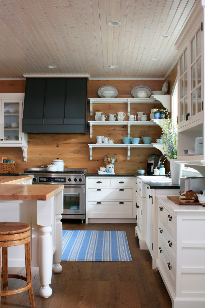 Klassische Küche mit offenen Schränken, Küchengeräten aus Edelstahl, Arbeitsplatte aus Holz, weißen Schränken und Landhausspüle in Sonstige