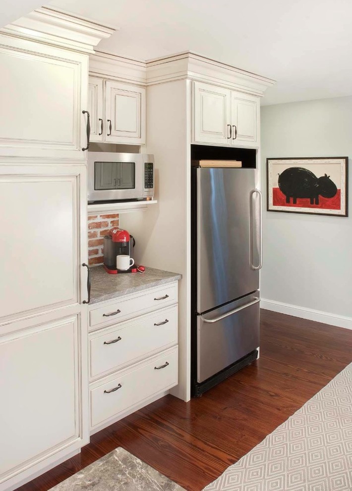 Imagen de cocina clásica con fregadero sobremueble, puertas de armario blancas, salpicadero de ladrillos, electrodomésticos de acero inoxidable y suelo de madera oscura