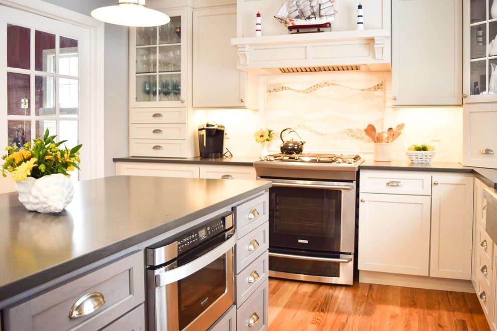 Foto de cocina clásica con fregadero sobremueble, electrodomésticos de acero inoxidable, suelo de madera clara y una isla