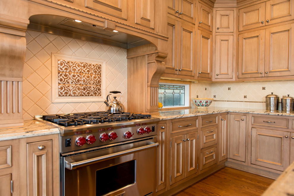クリーブランドにあるトラディショナルスタイルのおしゃれなキッチン (落し込みパネル扉のキャビネット、シルバーの調理設備、淡色木目調キャビネット) の写真