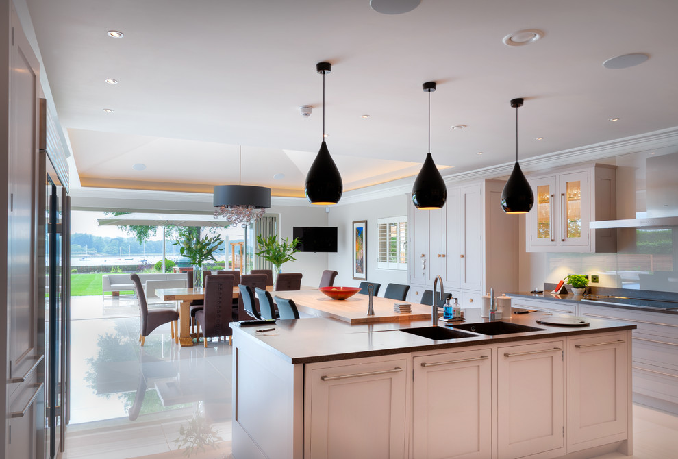 Стильный дизайн: кухня-гостиная в стиле неоклассика (современная классика) с фасадами в стиле шейкер, белыми фасадами и островом - последний тренд