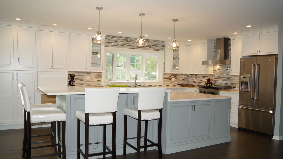 Photo of a large traditional l-shaped enclosed kitchen in Chicago with white cabinets, stainless steel appliances, dark hardwood flooring, an island, recessed-panel cabinets, multi-coloured splashback and a submerged sink.