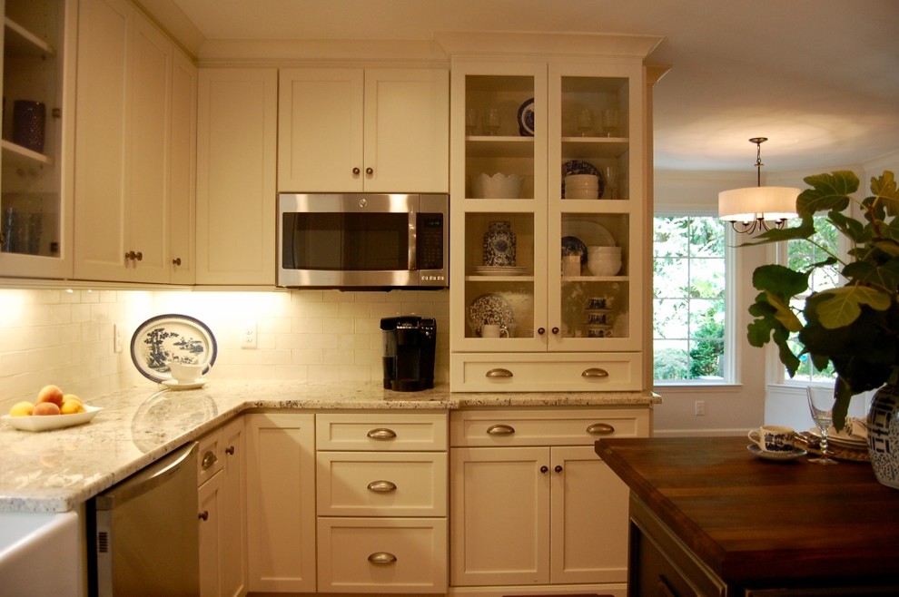 Esempio di un cucina con isola centrale chic con lavello stile country, ante bianche, elettrodomestici in acciaio inossidabile e pavimento in legno massello medio