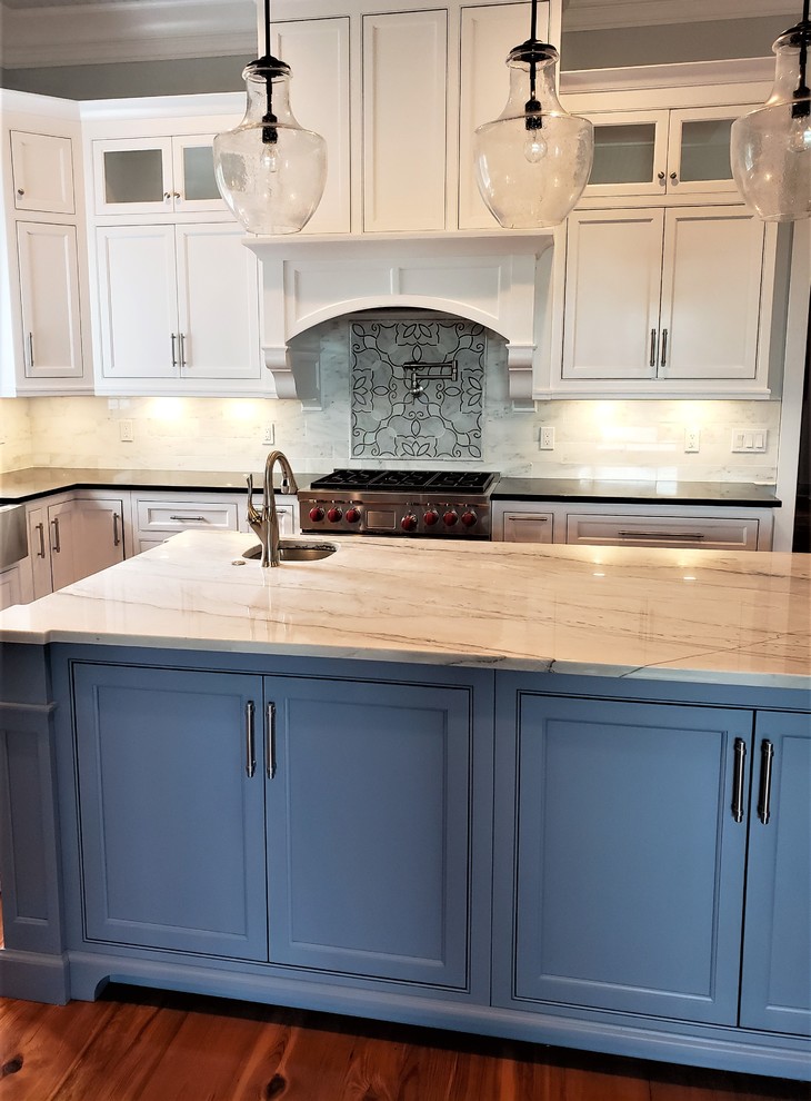 Ejemplo de cocina clásica de tamaño medio con puertas de armario turquesas, encimera de cuarcita, salpicadero blanco, salpicadero de azulejos de piedra, suelo de madera oscura, una isla, suelo marrón y encimeras blancas