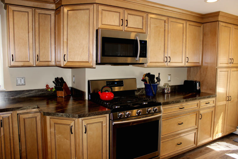 Exempel på ett klassiskt linjärt kök och matrum, med en dubbel diskho, skåp i ljust trä, laminatbänkskiva, rostfria vitvaror och mellanmörkt trägolv