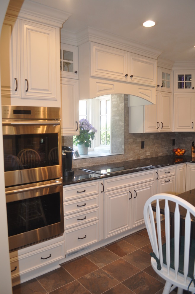 Mittelgroße, Geschlossene Klassische Küche in L-Form mit weißen Schränken, Küchenrückwand in Grau, Küchengeräten aus Edelstahl, Kücheninsel und profilierten Schrankfronten in Sonstige