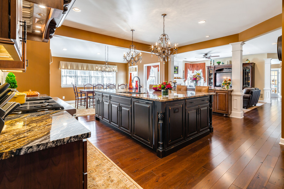 This is an example of a traditional kitchen in Philadelphia with dark wood cabinets, stainless steel appliances, medium hardwood flooring and an island.