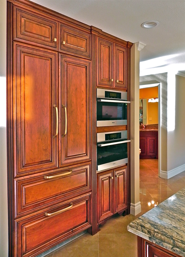 Exempel på ett mellanstort klassiskt kök, med en dubbel diskho, luckor med upphöjd panel, skåp i mellenmörkt trä, granitbänkskiva, flerfärgad stänkskydd, stänkskydd i sten, integrerade vitvaror, marmorgolv och en halv köksö