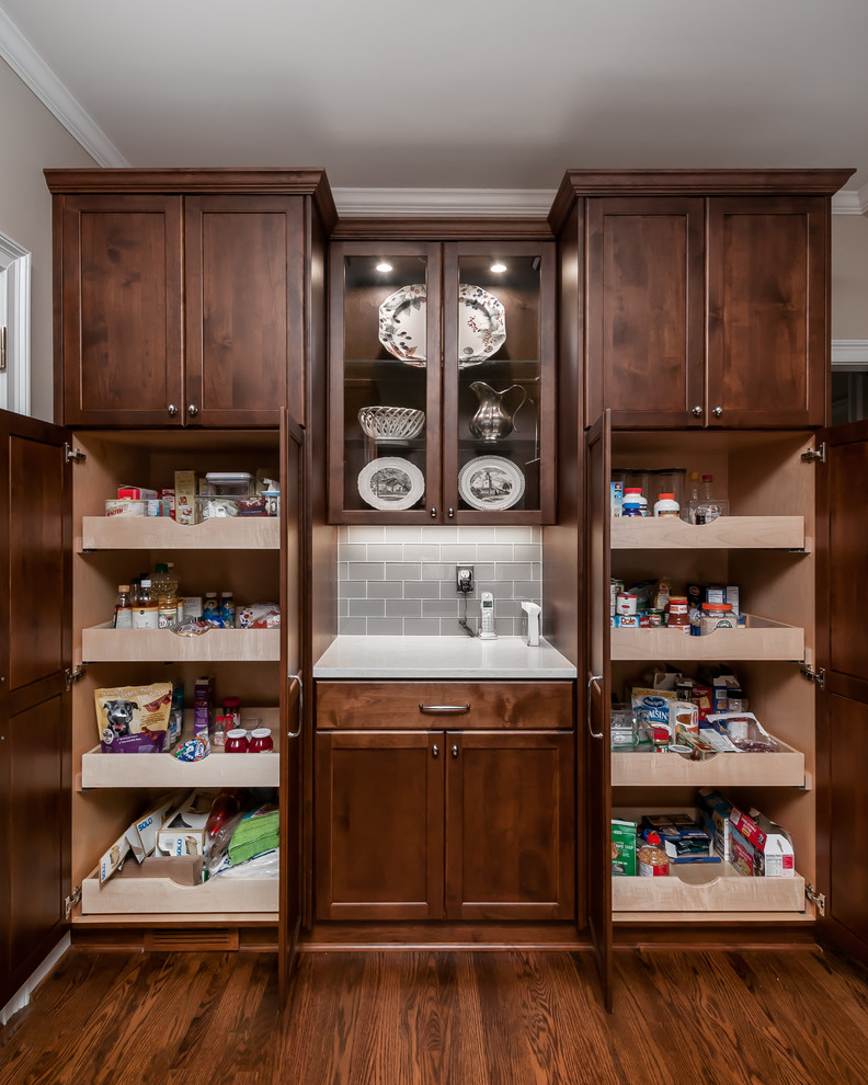 This is an example of a traditional kitchen pantry in Atlanta with shaker cabinets, medium wood cabinets, grey splashback, metro tiled splashback and medium hardwood flooring.