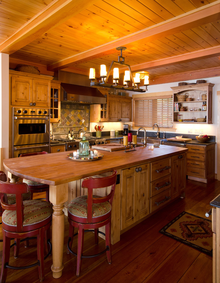 На фото: угловая кухня в классическом стиле с фасадами цвета дерева среднего тона, разноцветным фартуком, фартуком из плитки мозаики и техникой из нержавеющей стали с