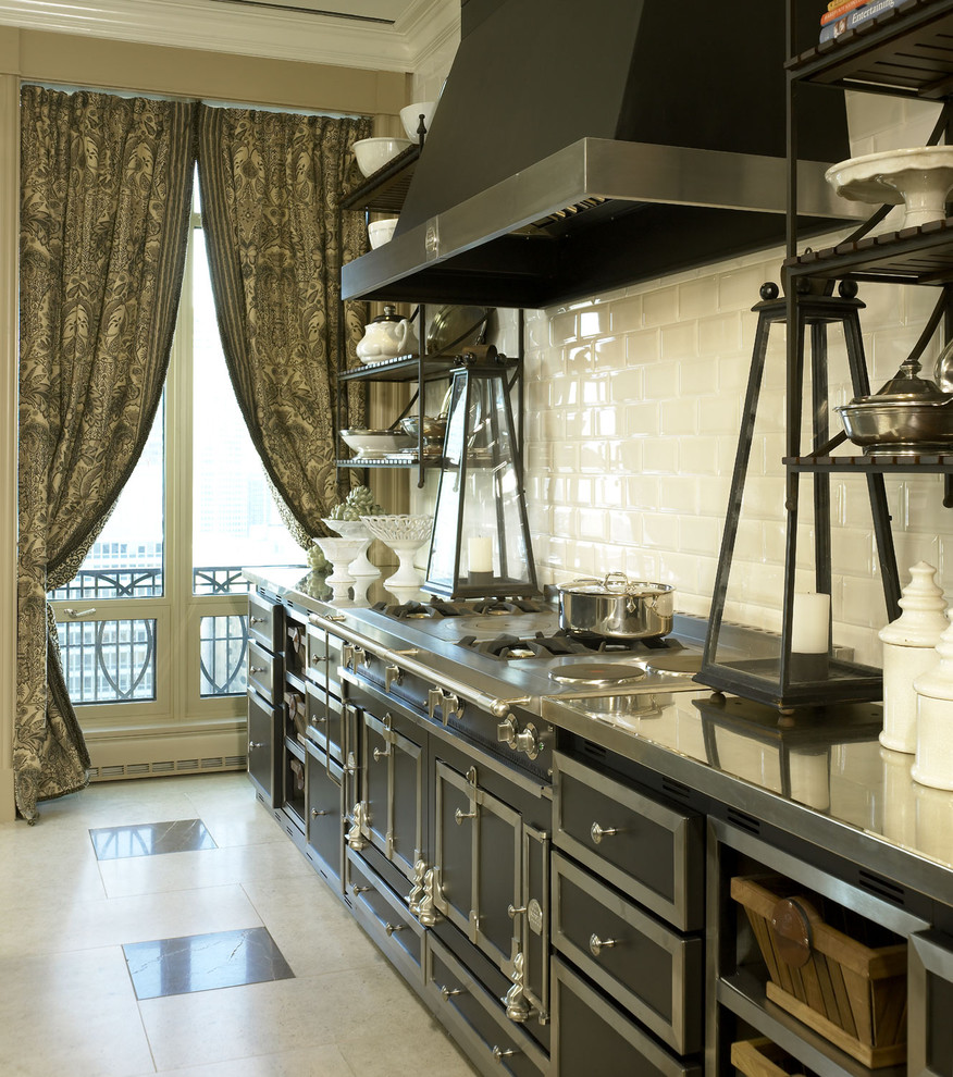 Diseño de cocina clásica con encimera de acero inoxidable, salpicadero blanco, salpicadero de azulejos tipo metro y electrodomésticos negros