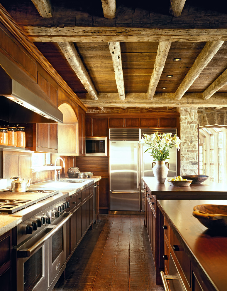 Imagen de cocina clásica con electrodomésticos de acero inoxidable, puertas de armario de madera en tonos medios y encimera de madera