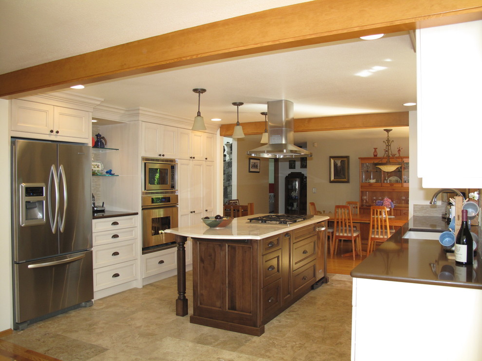 Klassisk inredning av ett stort kök, med en undermonterad diskho, luckor med infälld panel, vita skåp, bänkskiva i koppar, beige stänkskydd, stänkskydd i stickkakel, rostfria vitvaror, klinkergolv i porslin och en köksö