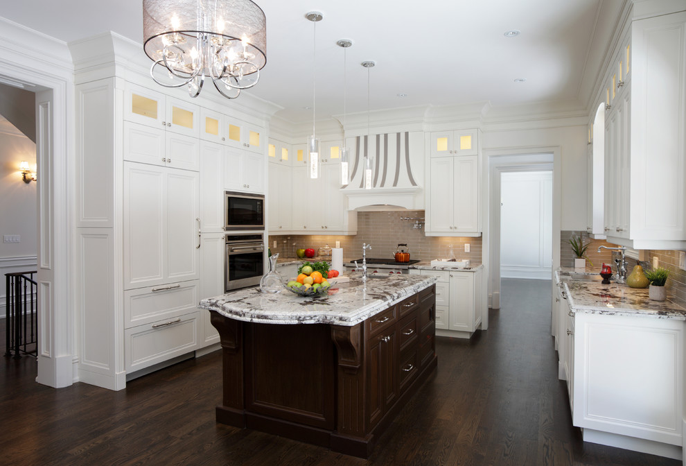 Kitchen - traditional u-shaped dark wood floor and brown floor kitchen idea in DC Metro with an undermount sink, recessed-panel cabinets, white cabinets, beige backsplash, subway tile backsplash, paneled appliances, an island and beige countertops